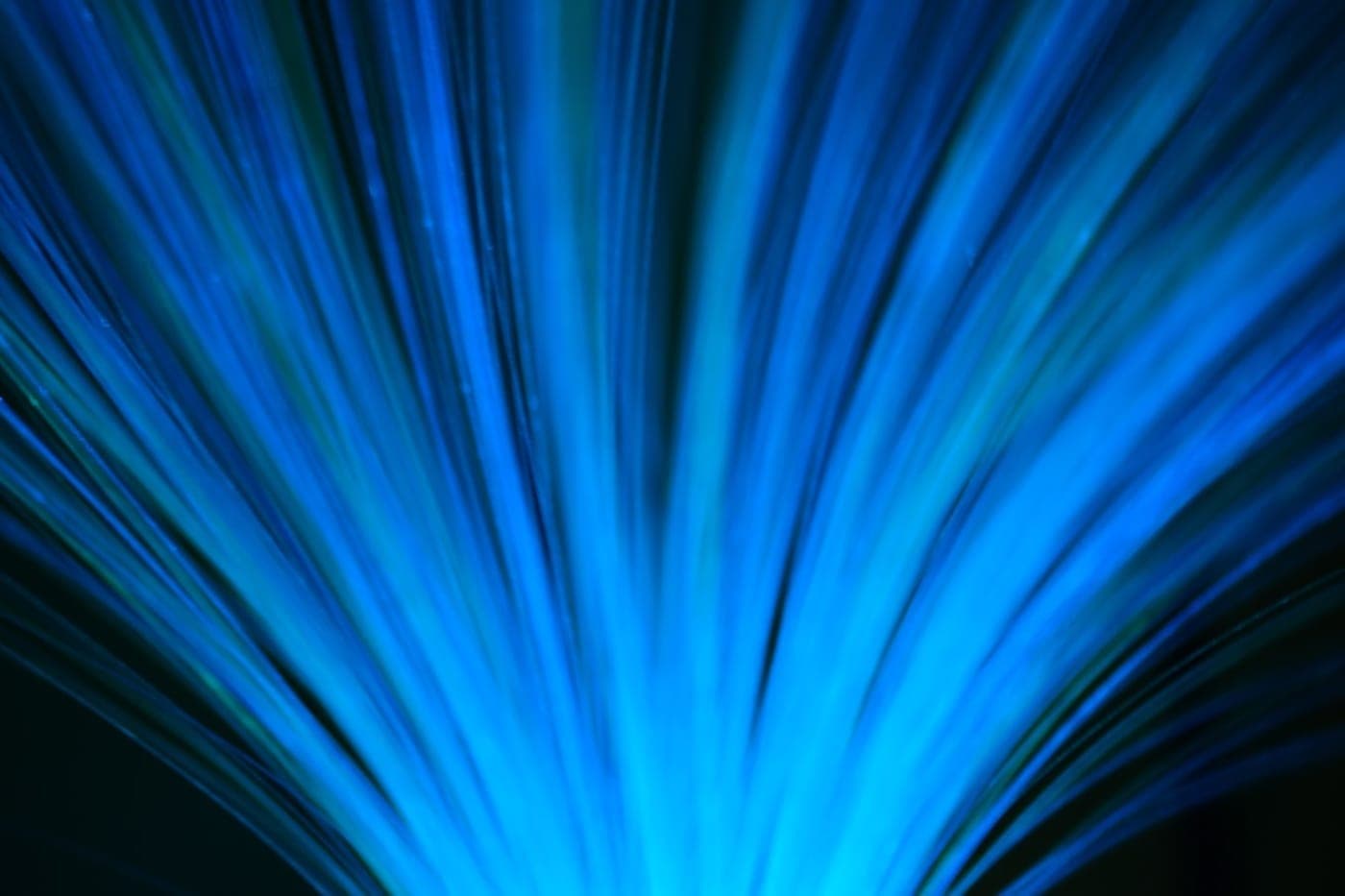 Glowing blue fiber-optic strands radiating outward against a dark background