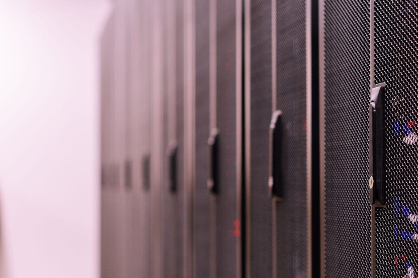 Row of locked black secure server racks receding with shallow depth of field
