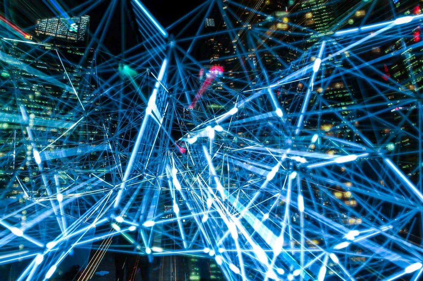 Abstract glowing blue network of light lines connecting across a dark cityscape