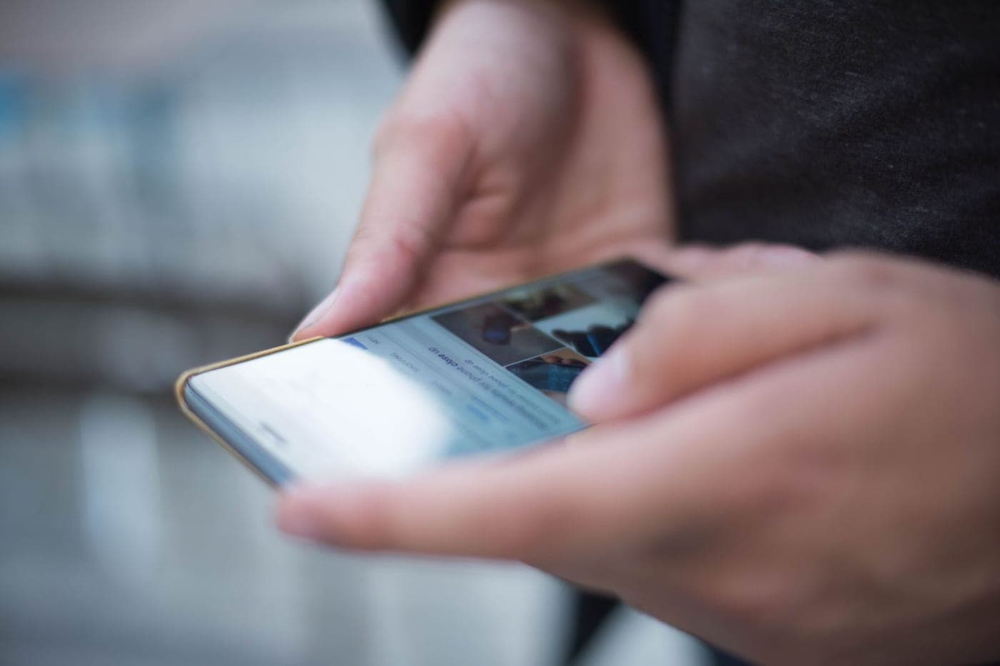 Hands holding and using a smartphone, shallow focus