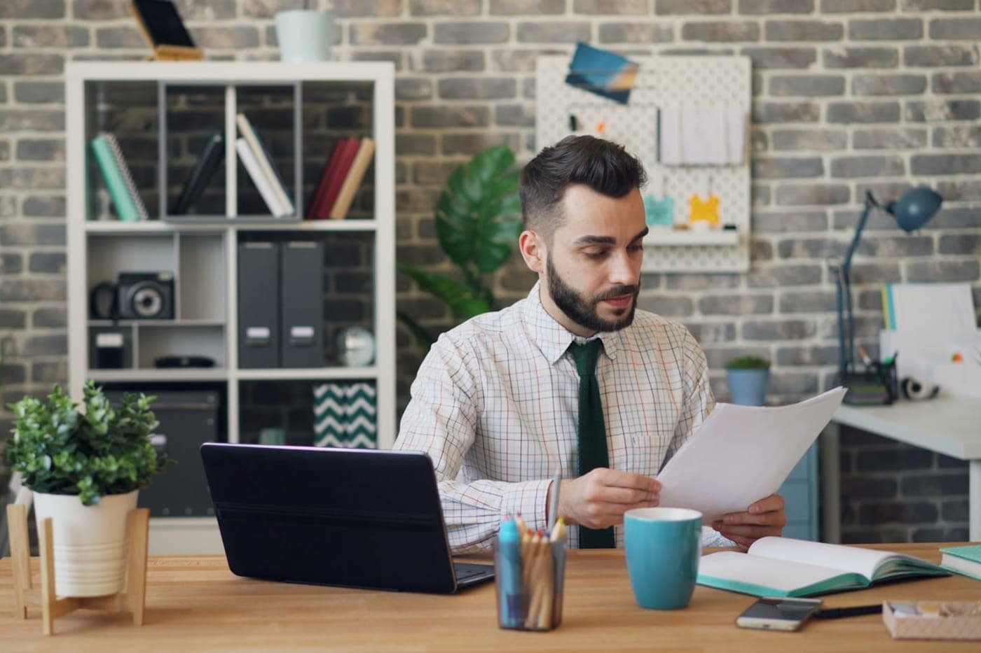 Person focused at a laptop in a bright modern workspace