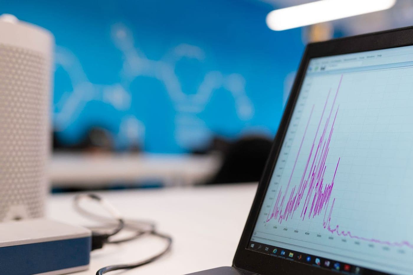 Laptop on a desk showing a clean line graph against a soft blue room