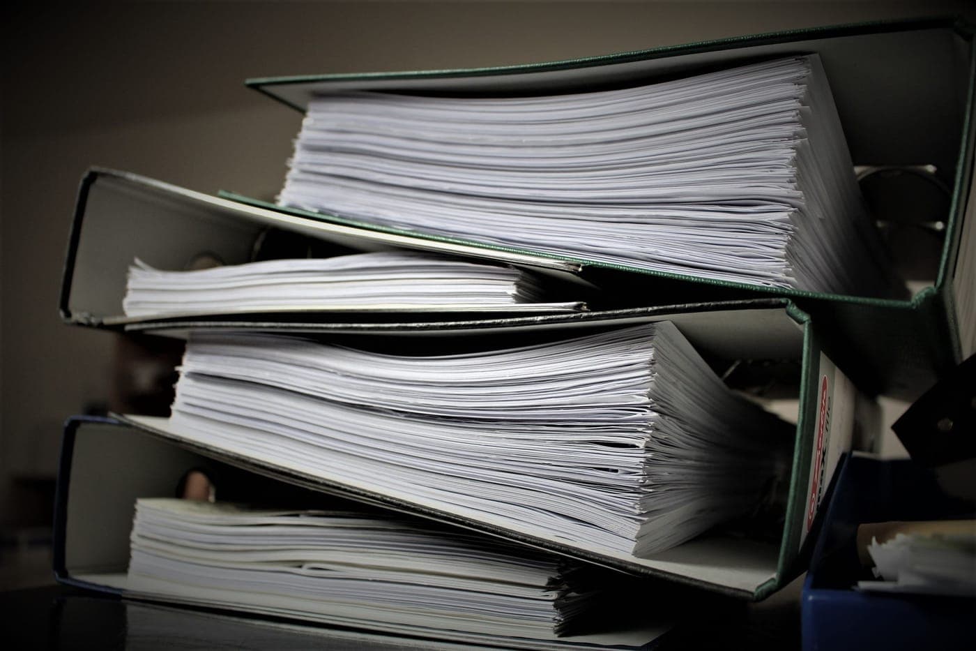 A stack of binders filled with documents